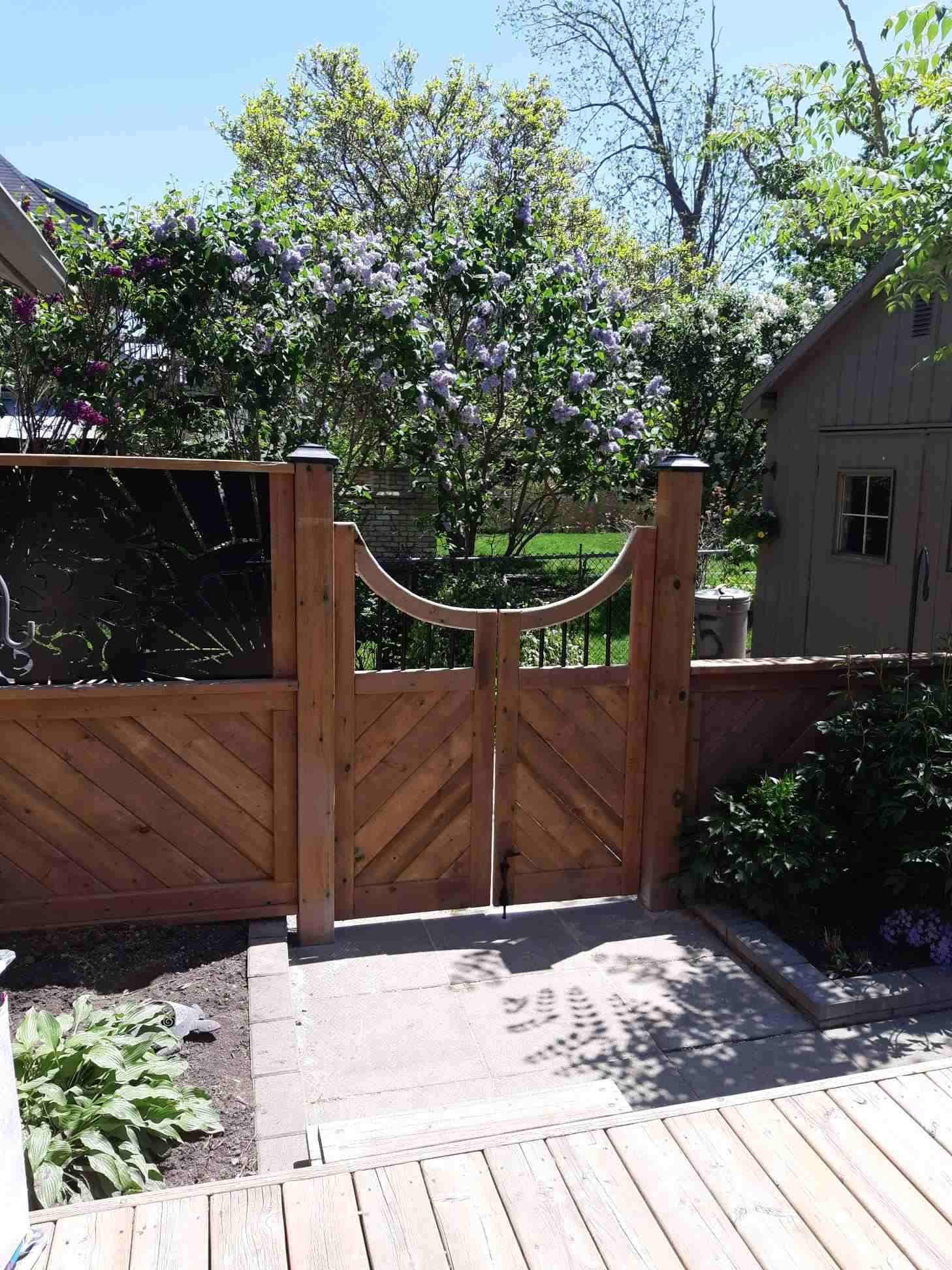 Custom curved-top wood gate with decorative metal panel insert