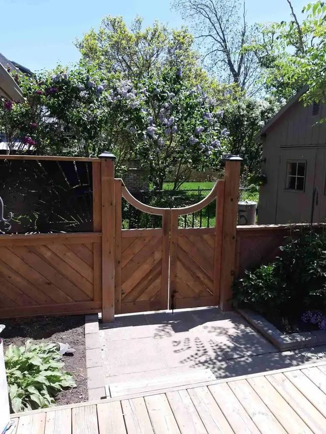 Custom wood gate with an arched top and chevron-pattern boards