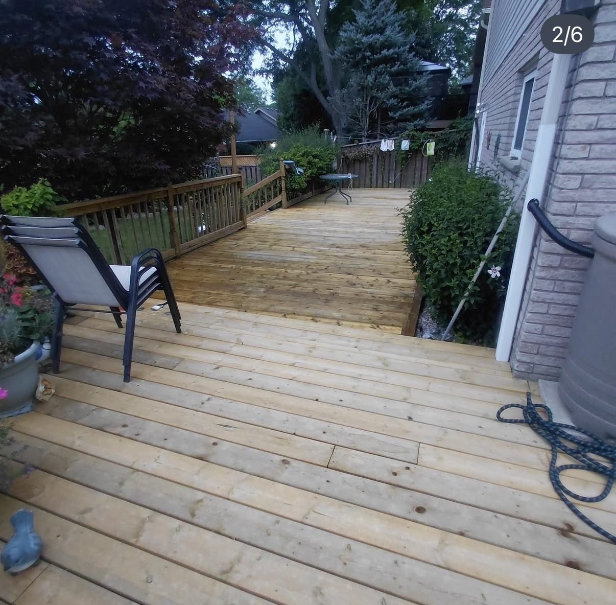 Wood deck with warm stain finish wrapping around a house in the evening light