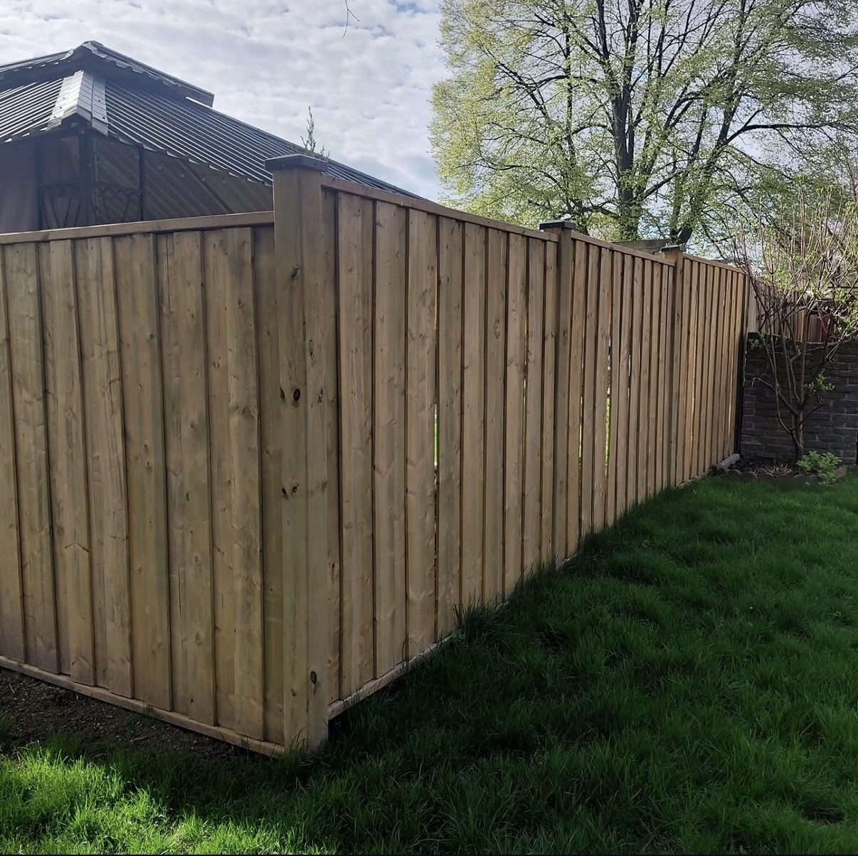 Tall wood privacy fence with lattice top along a side yard path
