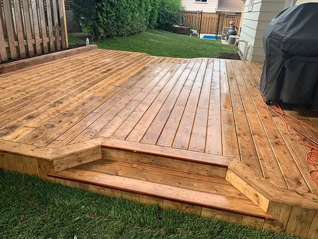 Ground-level wood deck with a step, built in London, Ontario