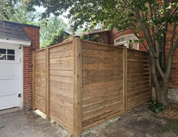 Horizontal wood privacy fence with tight boards and a top cap